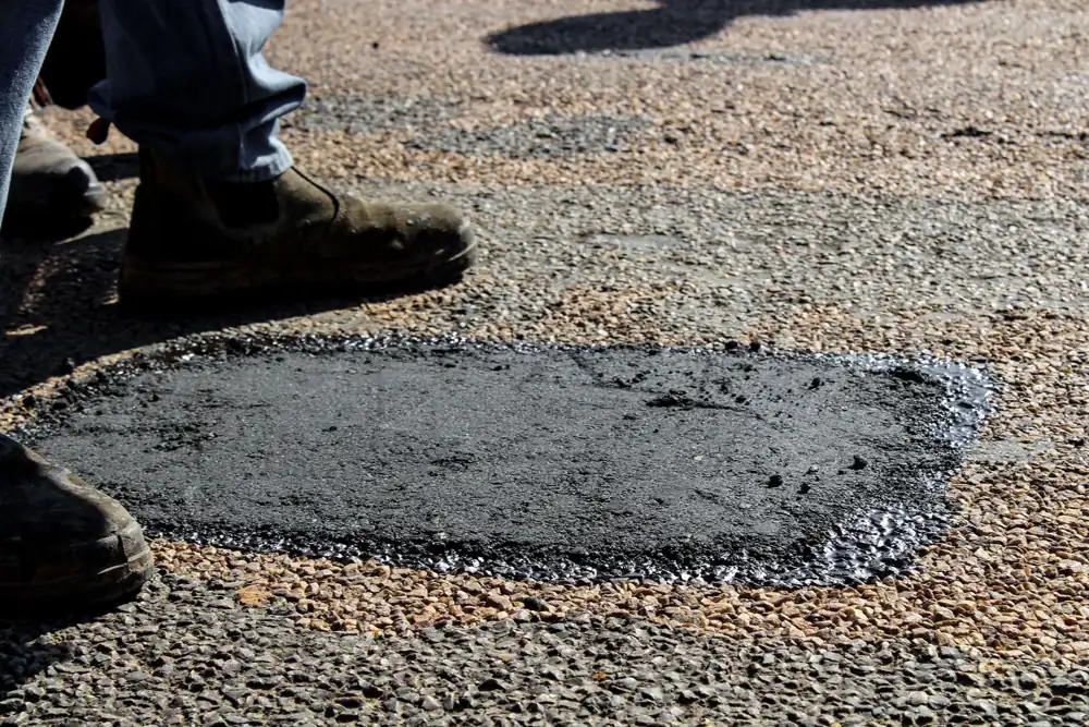 Freshly patched pothole in an asphalt surface